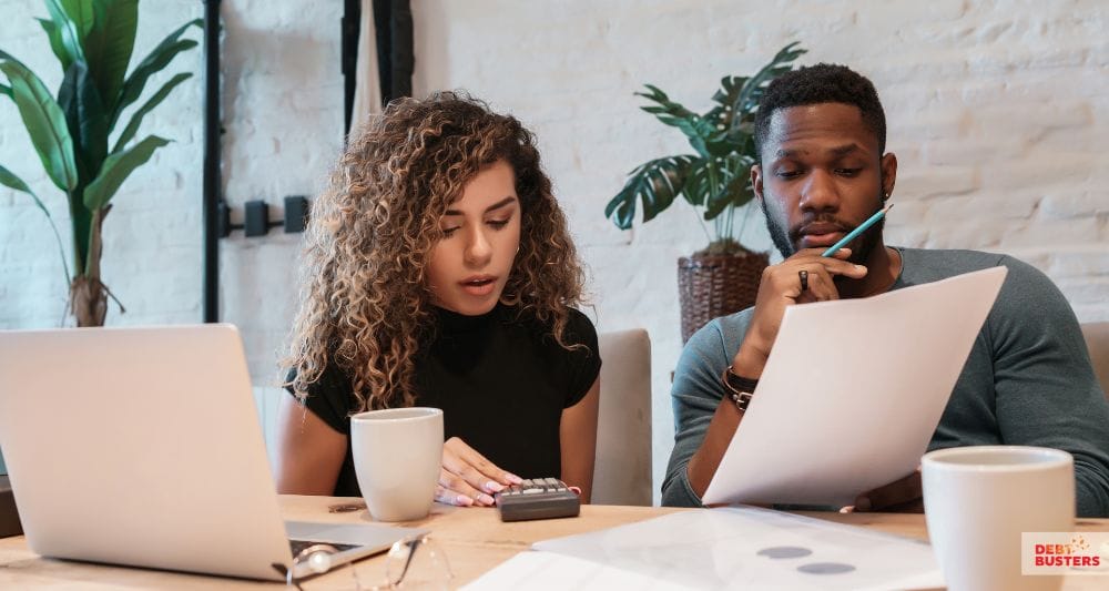 Couple reviewing bills while seeking charities that help with rent arrears in Australia.