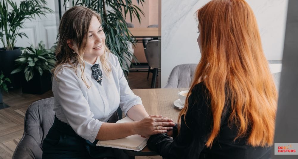 A support worker comforting a woman while discussing charities that help with rent arrears.