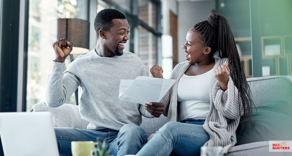Happy couple celebrating approval from charities that help with rent arrears in Australia.
